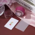 Detail view of a pink rhinestone nail art stamper, lace pattern plate, and scraper. - Rose Red