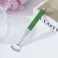 Close-up of a fan-shaped nail art brush featuring a sparkling green rhinestone-studded handle - Green