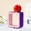 Detail of a 40ml square spray bottle with purple rhinestones and a red spherical cap - 40ml / Deep purple