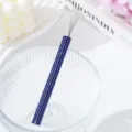 Close-up detail of a blue rhinestone encrusted nail art wire drawing tool in a bowl - Sapphire Blue