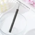 Macro detail of a rhinestone-encrusted nail art tool for spider gel with a black handle. - Black