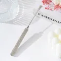 Close-up of rhinestone-encrusted handle on stainless steel nail art mixing tool stick - White