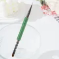 Primer plano de un pincel de nail art de doble punta con strass verdes - Verde