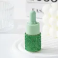 Close-up of a luxury green rhinestone essential oil dropper bottle on a white tray - 10ml / Green