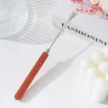 Close-up detail of stainless steel nail art mixing stick with vibrant orange rhinestone handle - Orange Red