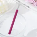 Macro detail of magenta rhinestone handle and metal wires of nail art drawing tool - Rose Red