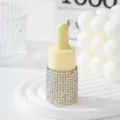 Close-up detail of a luxury rhinestone-studded dropper bottle on a white tiered display. - 10ml / AB White