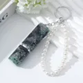 Close-up of a rhinestone-encrusted 5ml perfume bottle keychain with a faux pearl strand. - Green Blue Black Gradient