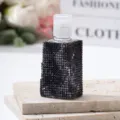 Detailed view of luxury black rhinestone encrusted travel spray bottle on stone base - 30ml / Black