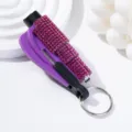 Macro view of a rhinestone-studded purple car window breaker and safety hammer - Rose Red