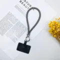 Detailansicht der glitzernden Handy-Handschlaufe mit Metallring und schwarzer Karte - Schwarz