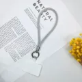 Nahaufnahme eines funkelnden silbernen Strass-Handy-Handgelenkband mit weißer Einlegkarte. - Silber