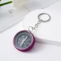 Close-up detail of a purple rhinestone-encrusted mini compass keychain for outdoor use - Rose Red
