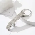 Close-up detail of silver rhinestone-encrusted aluminum alloy bottle opener keychain. - White