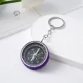 Detailed close-up showing purple rhinestone encrusted mini compass keychain for outdoor use - Purple