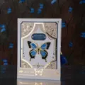 Close-up detail of the vintage gothic butterfly notebook with golden foil stamping and tassel. - Style B (White)