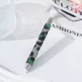 Detail view of a dual-ended rhinestone dotting pen with green camouflage pattern for nail art - Green Leopard