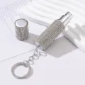 Detail view of a portable rhinestone-encrusted perfume atomizer with keychain attachment. - 5ml / White