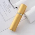 Primer plano de un atomizador de perfume de 5ml oro mate con carcasa de aluminio - Dorado