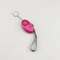 Close-up detail view of pink egg-shaped personal alarm with metal keychain and grey wrist strap - Rose Red