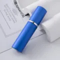 Detalle macro de un frasco pulverizador de perfume de 5ml en aluminio azul y vidrio. - Azul