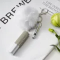 Vue détaillée du flacon de parfum en strass et du pompon blanc sur un porte-clés de 3 pièces. - Ensemble de Pendentifs 3 Pièces / Blanc
