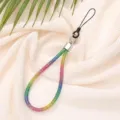 Close-up detail of a rainbow rhinestone phone wrist strap on a soft pleated fabric background - Gradient Rainbow