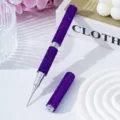 Macro view of purple rhinestone-encrusted double-ended nail art liner and dotting pen - Deep purple