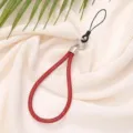 Detailed view of luxury 6mm red rhinestone phone wrist strap on textured fabric - Red