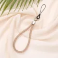 Detail view of a luxury 6mm rose gold rhinestone phone wrist strap on soft fabric. - Champagne Gold
