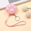 Detalle de cerca de la alarma inteligente con forma de pata de gato rosa y cordón de mano - Rosa
