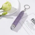 Close-up of a mini LED keychain flashlight decorated with shiny purple rhinestones - Without Battery / Purple
