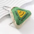 Primer plano de un monedero triangular de lona verde con un parche de cara sonriente - Llavero / Verde