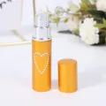 Detalle del frasco pulverizador de viaje de 5ml en aluminio dorado con corazón de strass - Dorado
