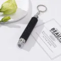 Close-up of a stylish black rhinestone LED flashlight keychain on a white surface. - Without Battery / Black