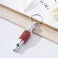 Detail of survival whistle with red rhinestones and aluminum alloy keychain attachment - Orange