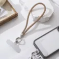 Close-up of a sparkling rhinestone phone lanyard with a metal clasp on a white case. - Khaki