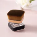Gros plan d'un pinceau à maquillage carré de luxe avec manche orné de strass noirs - Noir