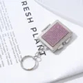 Detailed view of a mini silver keychain with sparkling pink rhinestones and a mirror - Pink