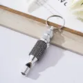 Close-up view of a silver aluminum alloy whistle keychain decorated with shiny rhinestones - Gray