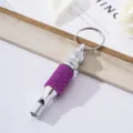 Detailed view of a silver aluminum survival whistle keychain featuring purple rhinestones - Rose Red