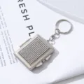 Close-up detail of a silver rectangular mini makeup mirror keychain with rhinestones - White