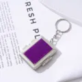 Detail view of purple rhinestone mini makeup mirror keychain with silver metal frame - Purple