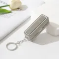 Detail eines luxuriösen Strass-Lippenstiftetuis mit Kristallglanz und Schlüsselanhänger. - Weiß