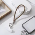 Detailopname van de glinsterende bronzen strass-telefoonpolsband met zilveren sluiting - Donkerbruin