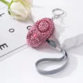 Close-up of a pink rhinestone personal safety alarm for women on a white stone - Pink