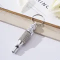 Macro view of a silver aluminum emergency survival whistle with sparkling rhinestone detailing - White