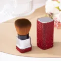 Luxury red rhinestone encrusted makeup brush detail showing dense brown bristles - Red (White Base)