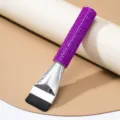 Close-up detail of luxury purple rhinestone handle on professional flat foundation brush - Purple