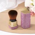 Detail of pink rhinestone-studded nail dust brush with gold-toned finish and cap. - Pink (Gold Base)